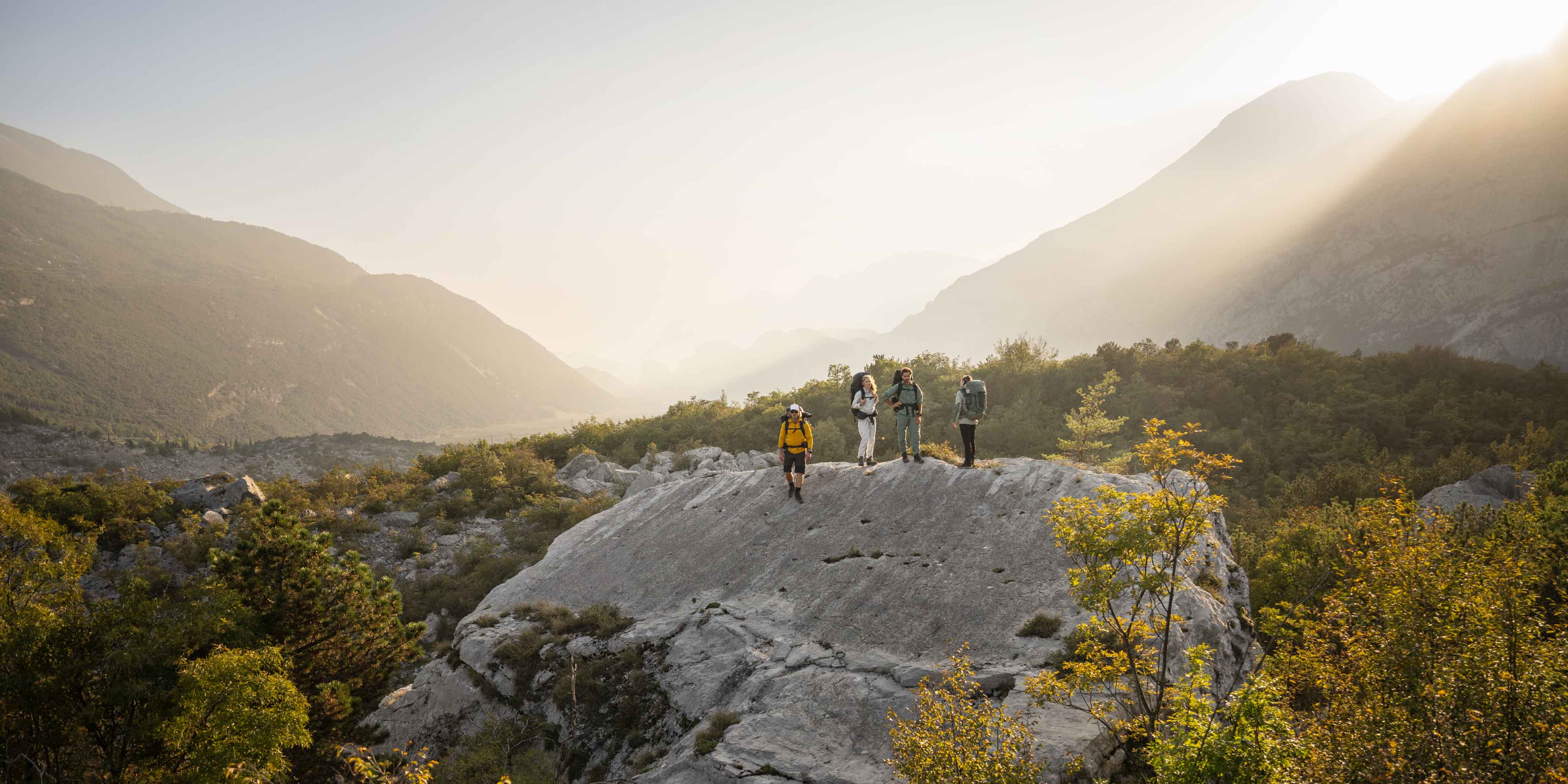 group hiking on a hillside rock