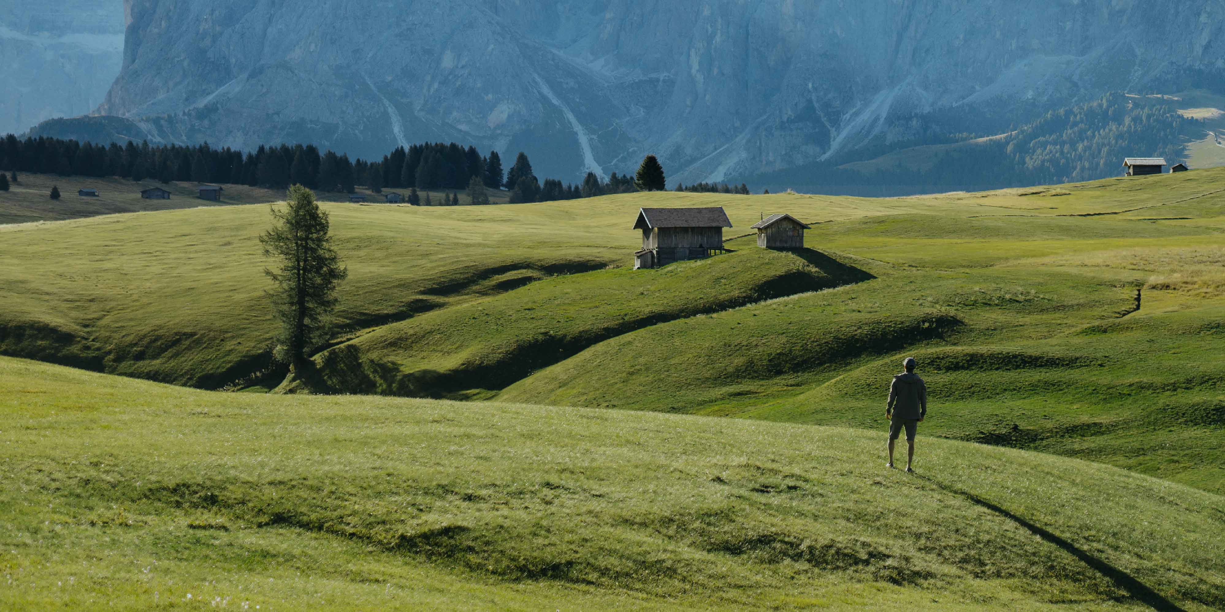 man standing on rolling hills