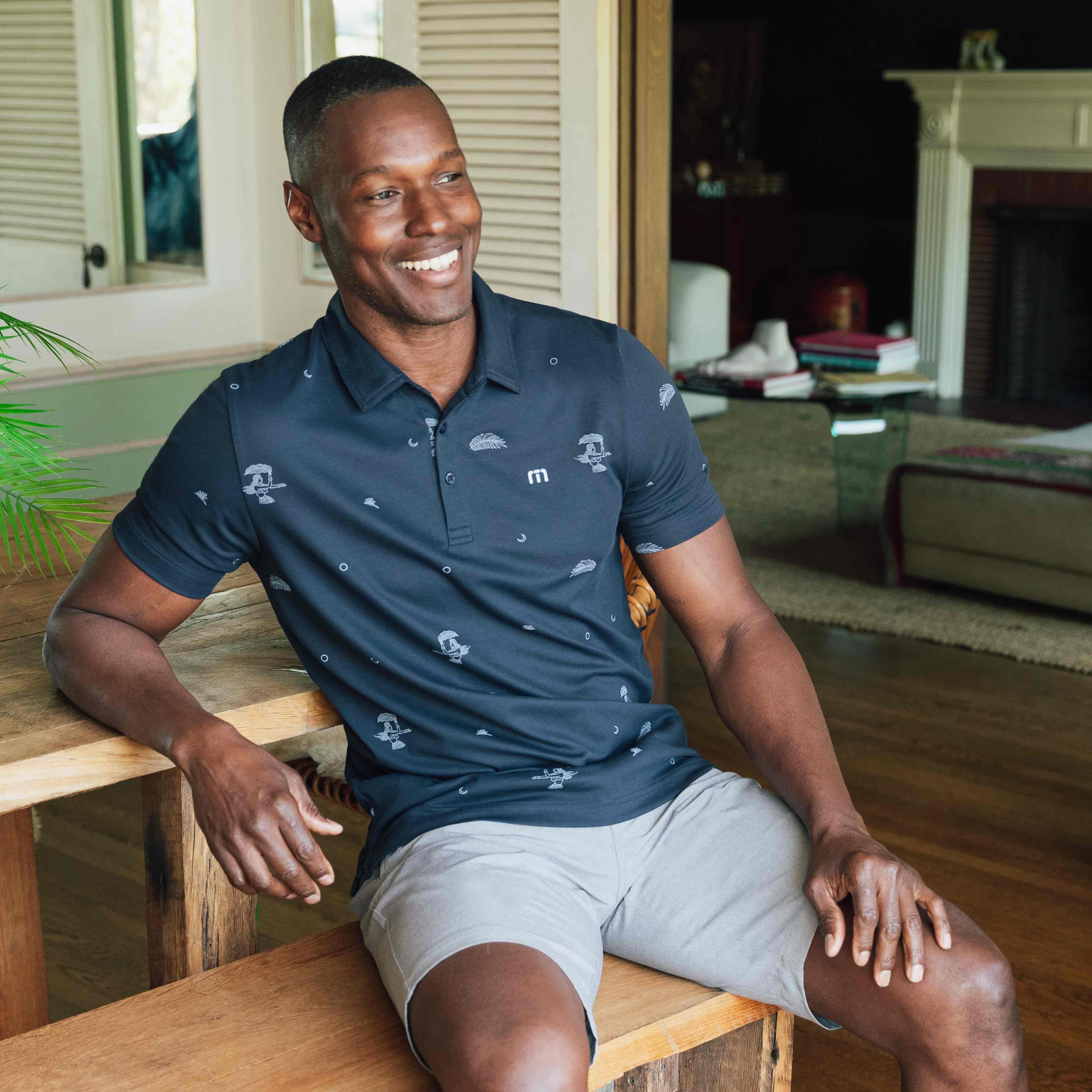 man smiling in blue shirt and grey shorts