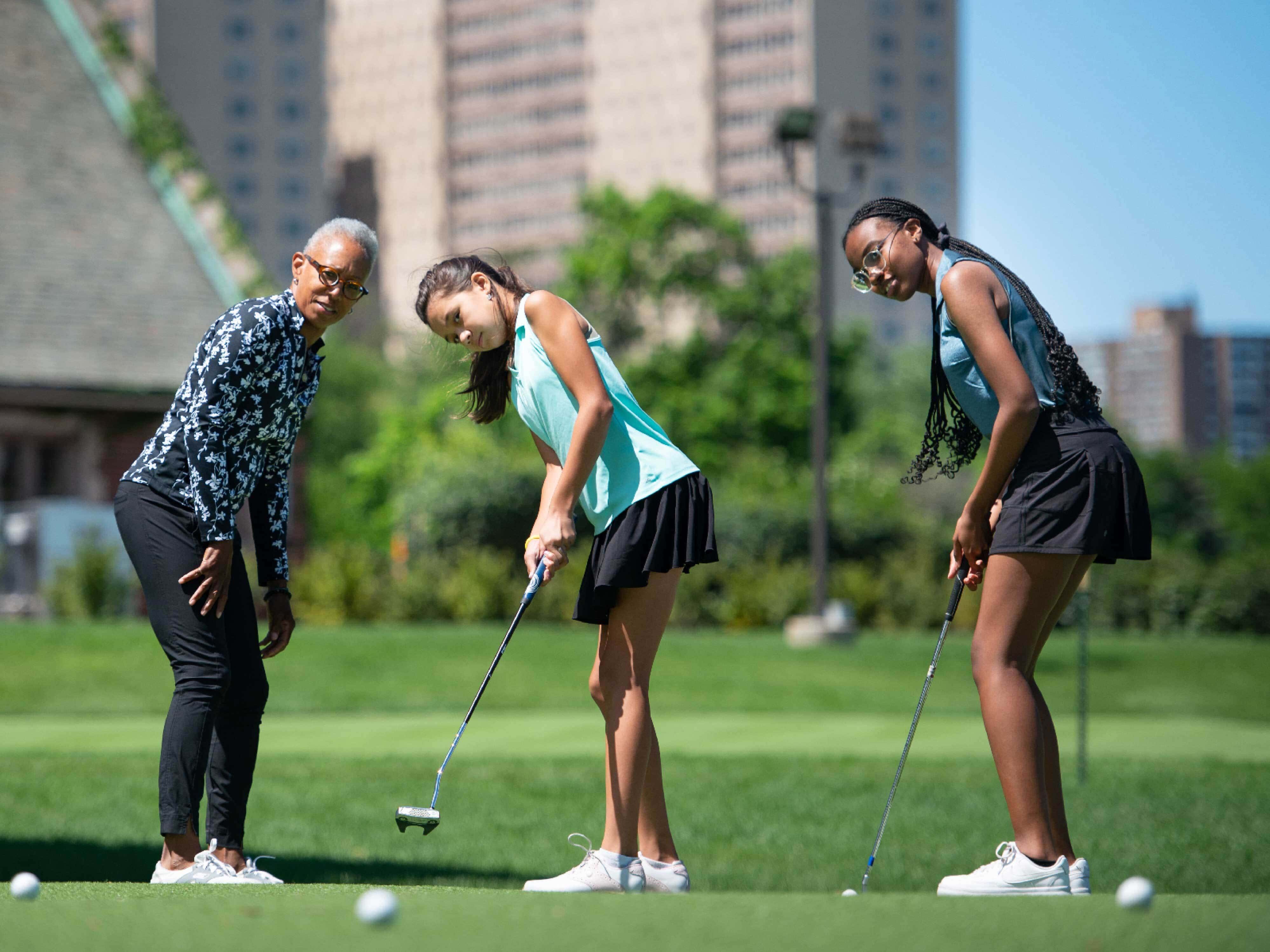 three women playing golf