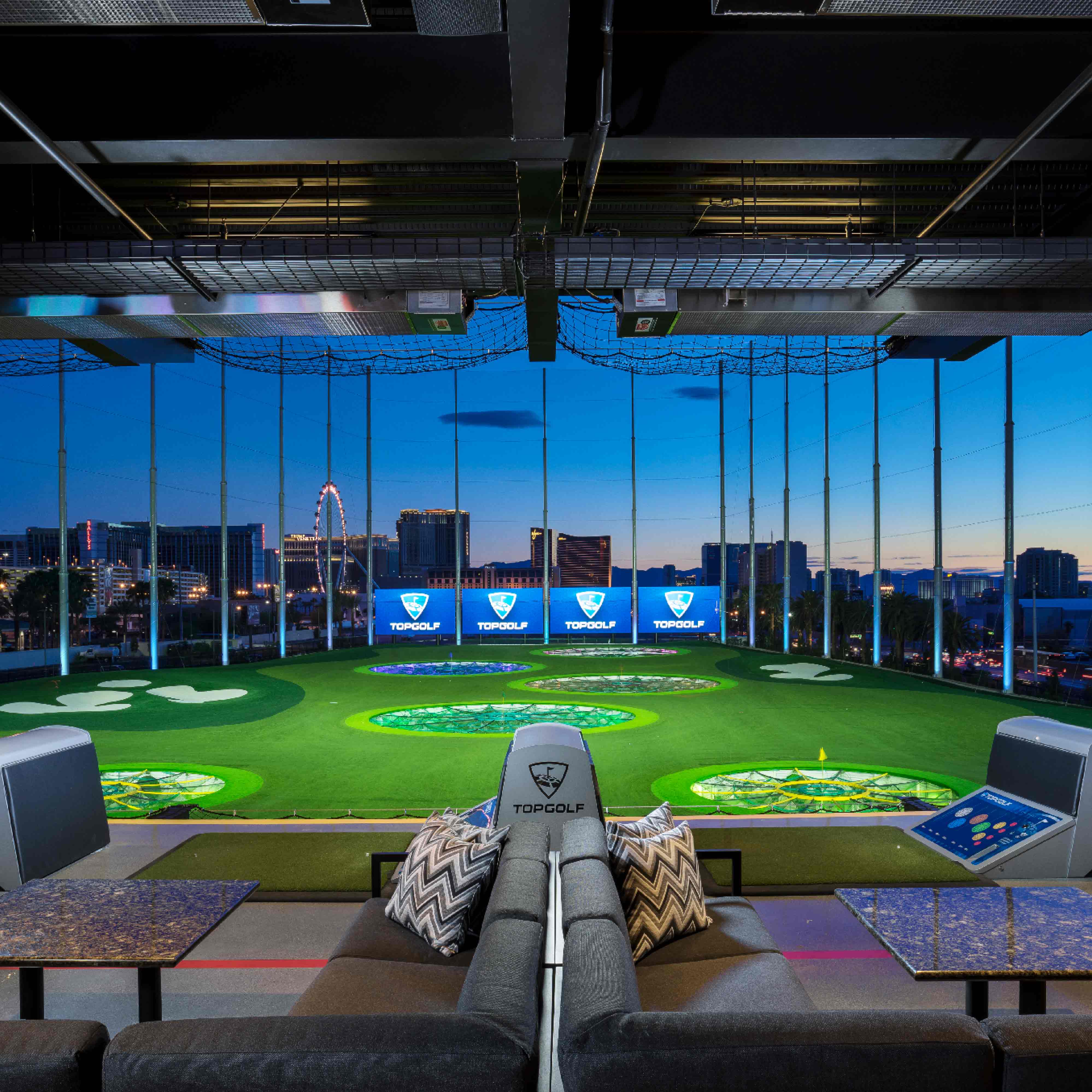 a room with a large green field and a large city skyline