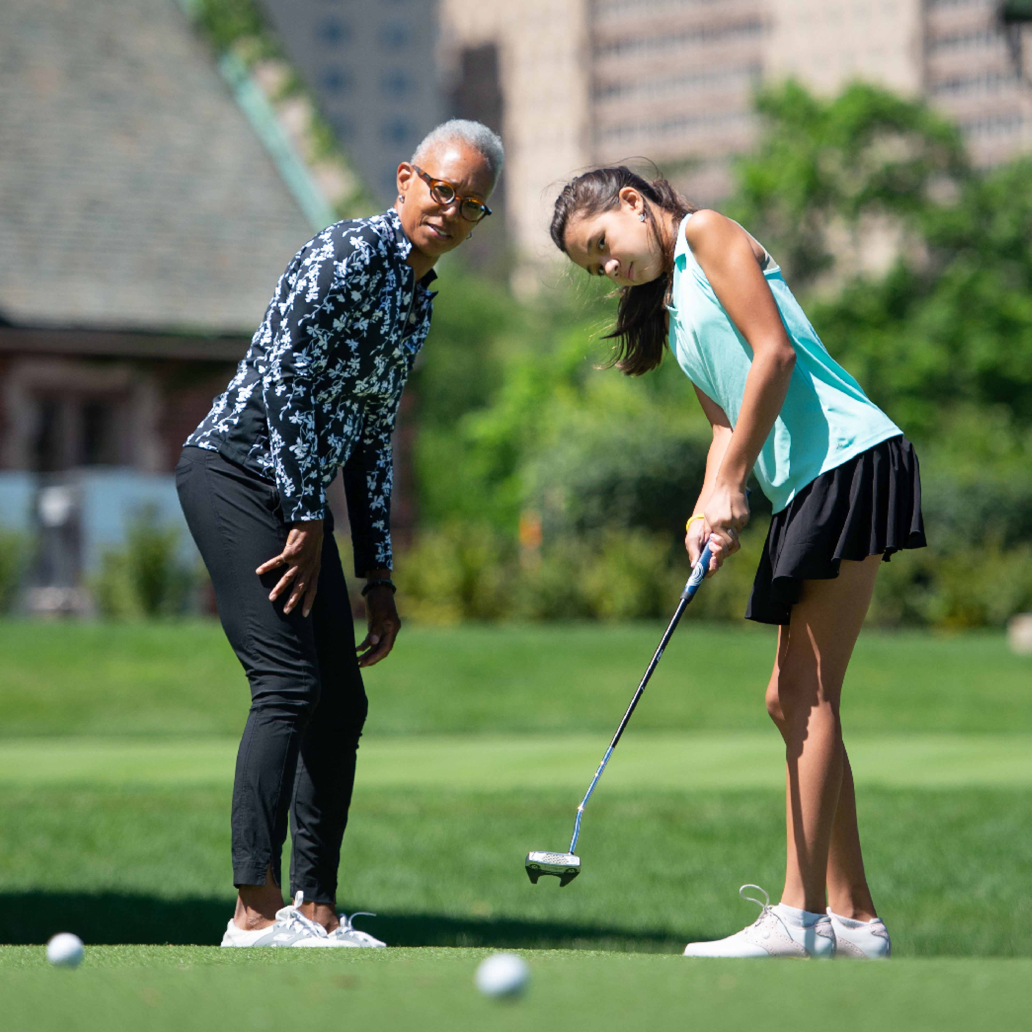 a woman and a girl playing golf